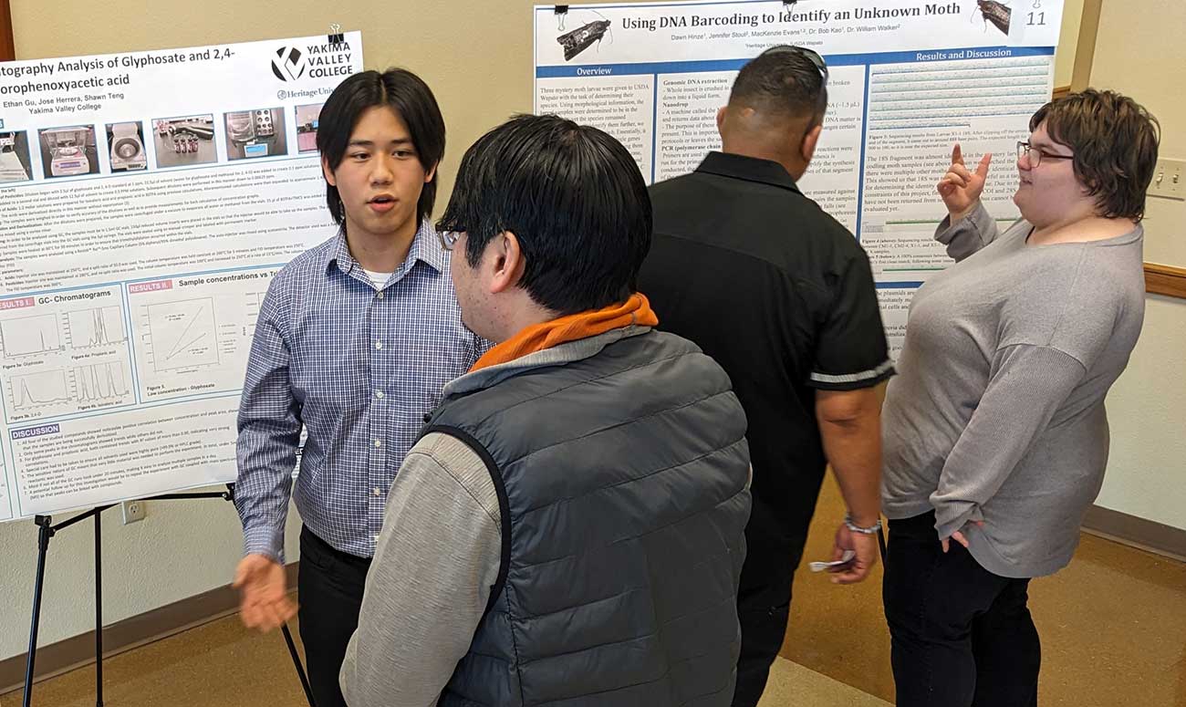 One student talks to another during a presentation. 