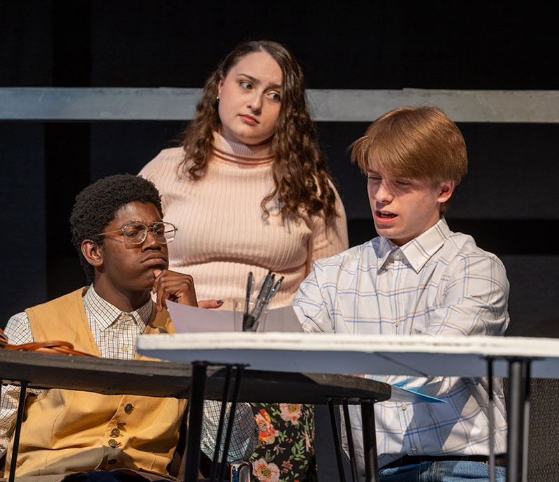 Three students acting in the spring production. 