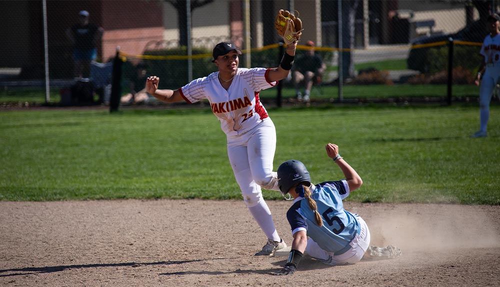 YVC softball second-base defender catches ball to get out against sliding runner.