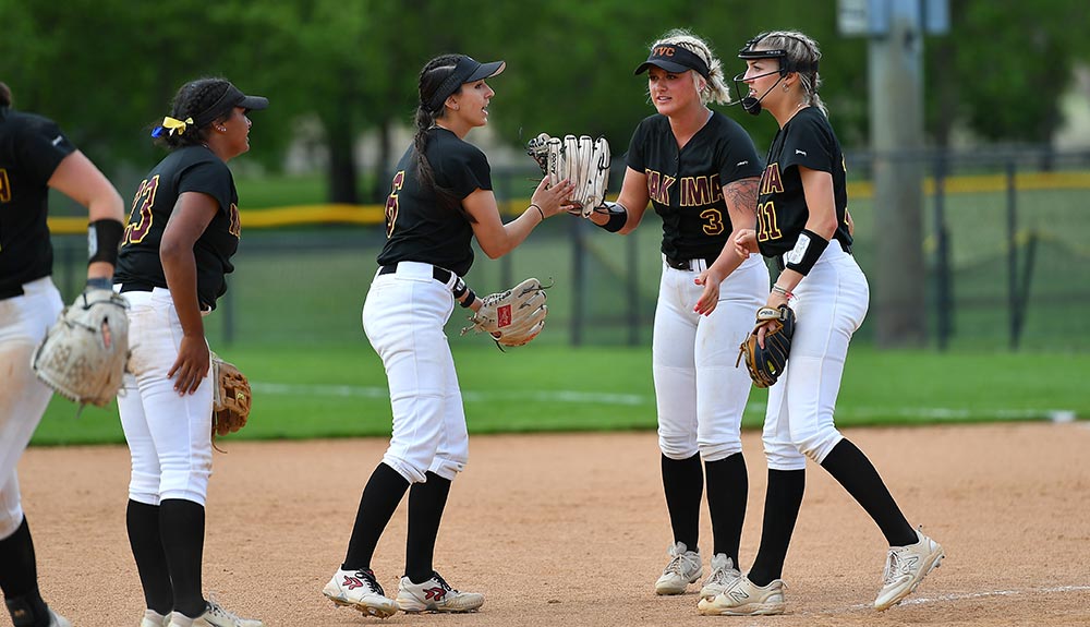 Yakima Valley College softball players celebrate at end of inning