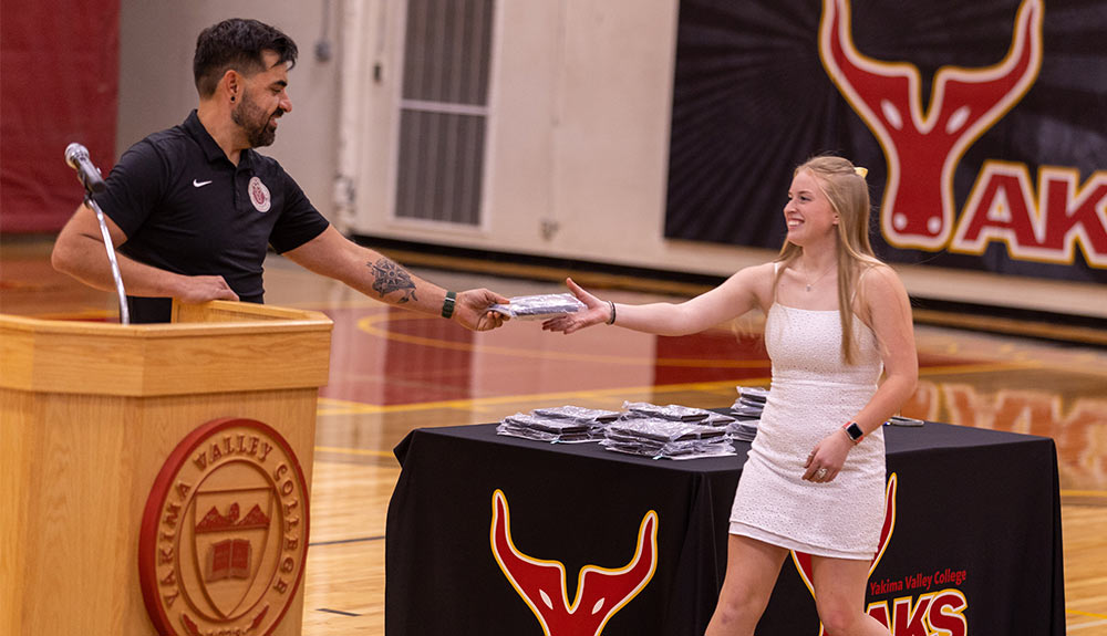 Women's soccer head coach Josh Vega hands award to player Kylen Mark. Women's Soccer Head Coach Josh Vega hands the team's R.I.S.E. Award to freshman Kylen Mark.