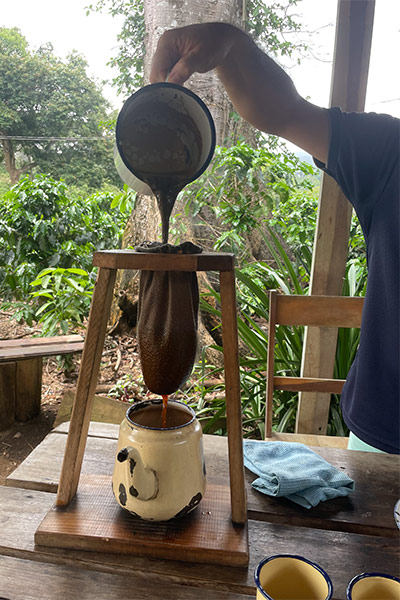 A barista pours water into a traditional Costa Rican correador to brew a cup of coffee.