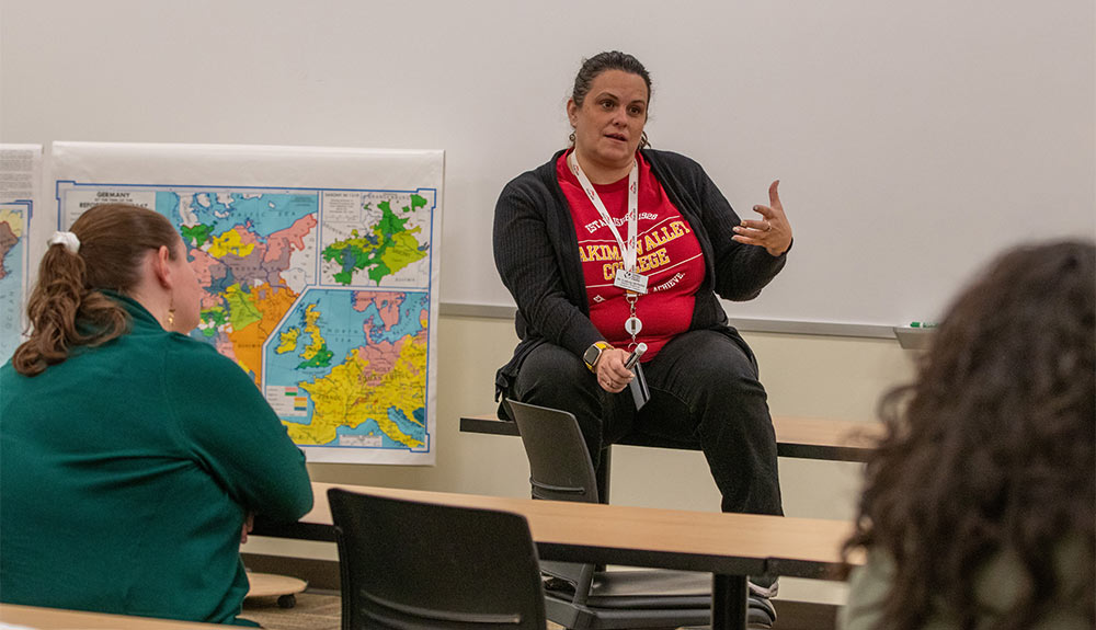 Instructor Lindsey McNellis talks to students during a geography course