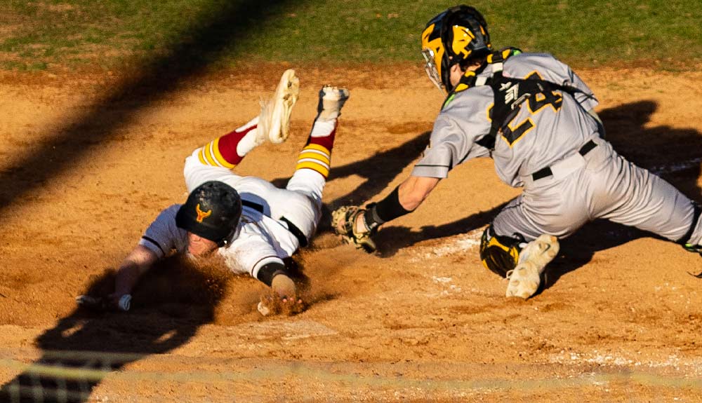 Yakima Valley College baseball player slides to avoid tag at home plate