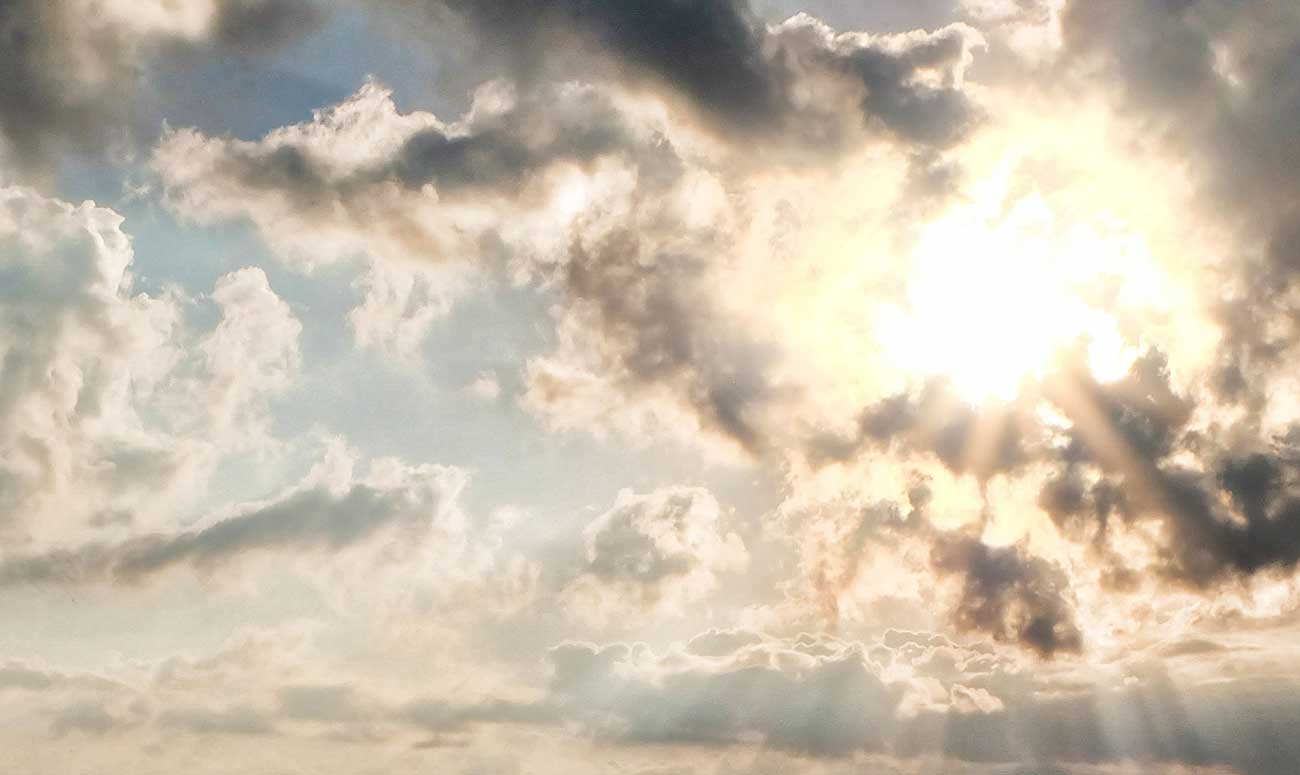 Picture of the sun shining through the clouds