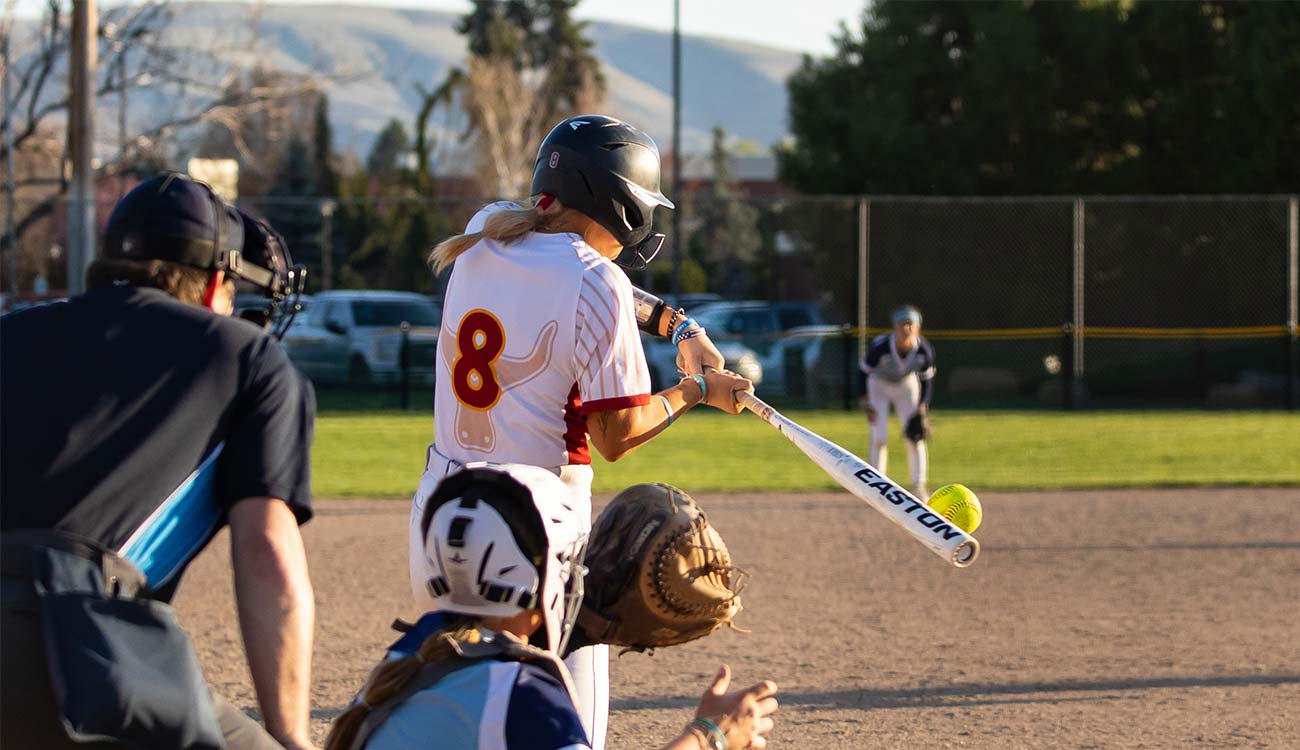 YVC softball player wearing number 8 hits the ball during a game. 