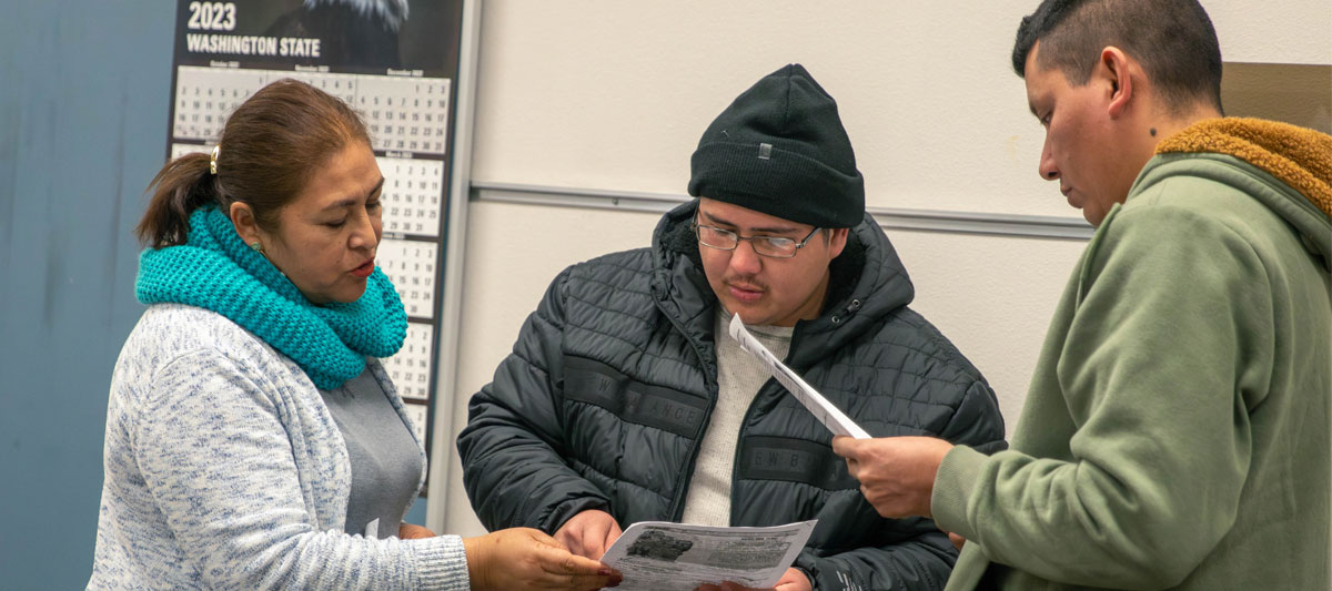 YVC staff member works with two students. 