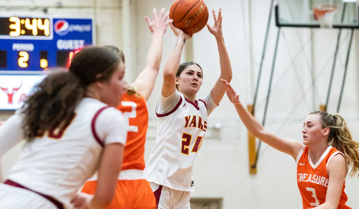 A basketball player shoots the ball during a game