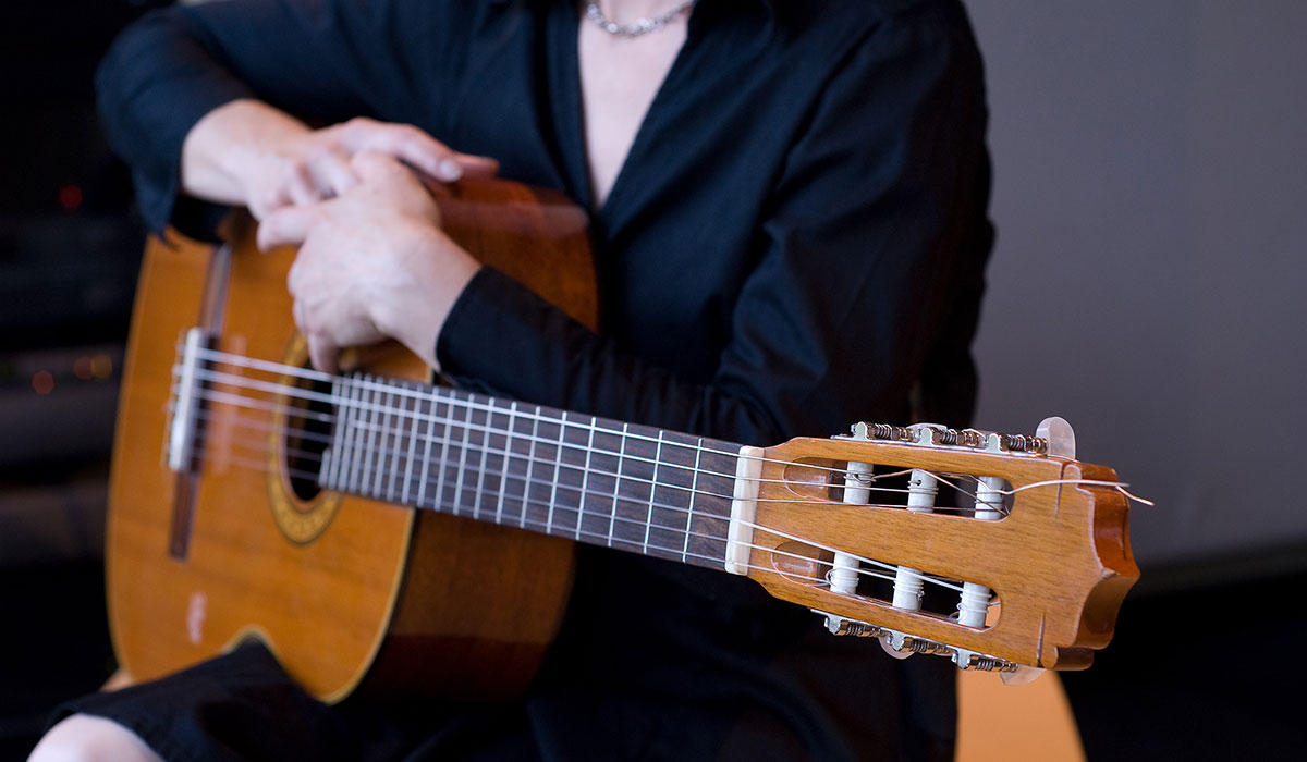 A woman holds a guitar