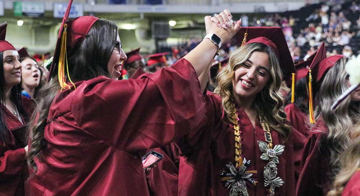 Two students celebrate at commencement ceremony