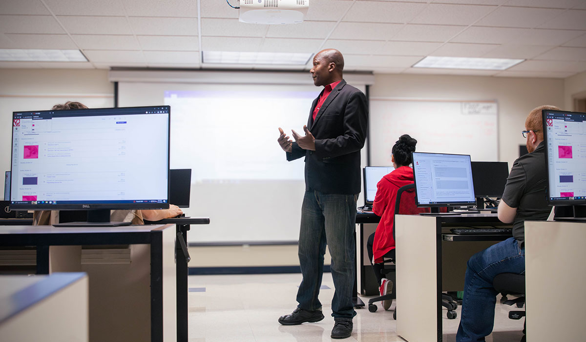 Students listen to lecture from Peter Udo for the BASIT program