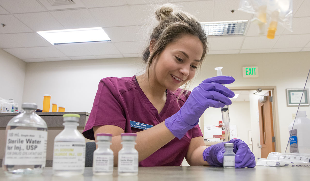 A pharmacy technician student works on a lab