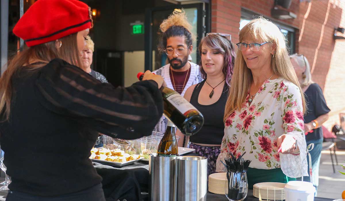 Guests wait in line for a glass of wine during the French Market event