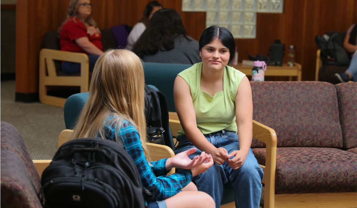 Two students sit in common area at YVC.