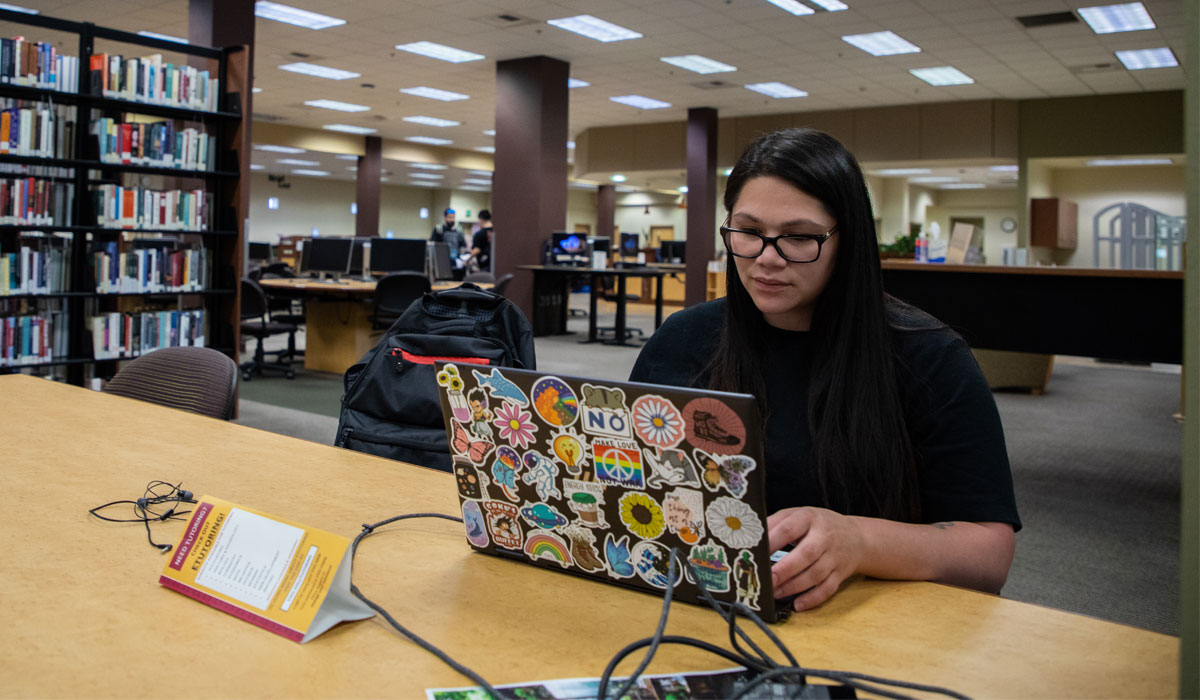 Student works on her lap top in the library. 