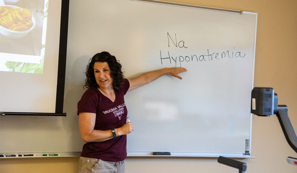 YVC instructor writing on whiteboard during class. 