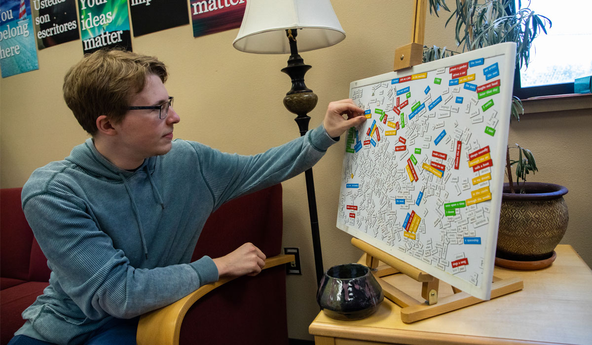 YVC student plays with magnets on the whiteboard. 