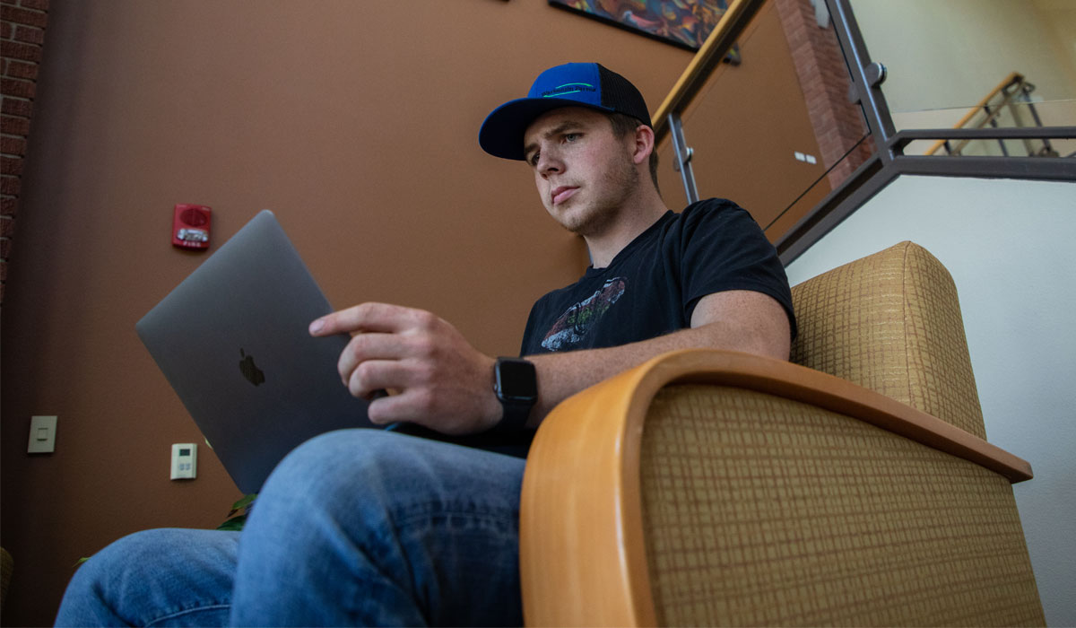 Student works on computer between classes. 