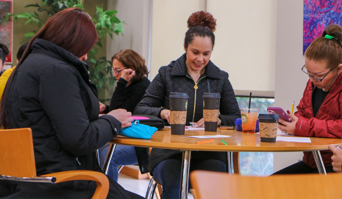 Students sitting at a table working on their notebooks. 