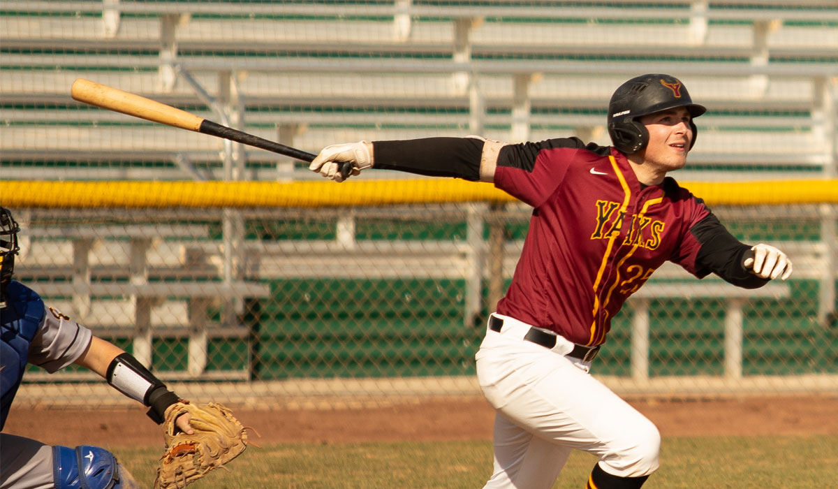 YVC baseball player watches ball as he begins to run. 