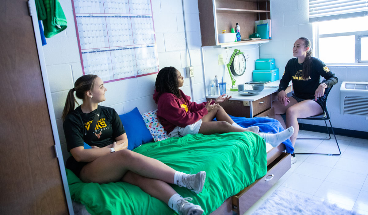 Three students in a YVC dormroom.