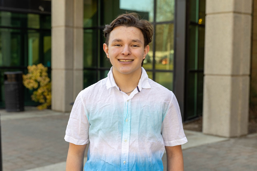 Andrew Escamilla poses for Student Story picture in front of an academic building on the YVC campus. 