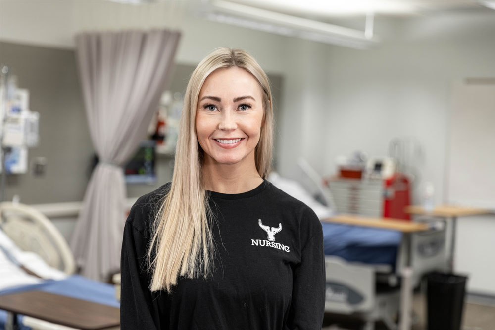 Ashley Curtin poses for Student Story Photo in a YVC Healthcare room. 