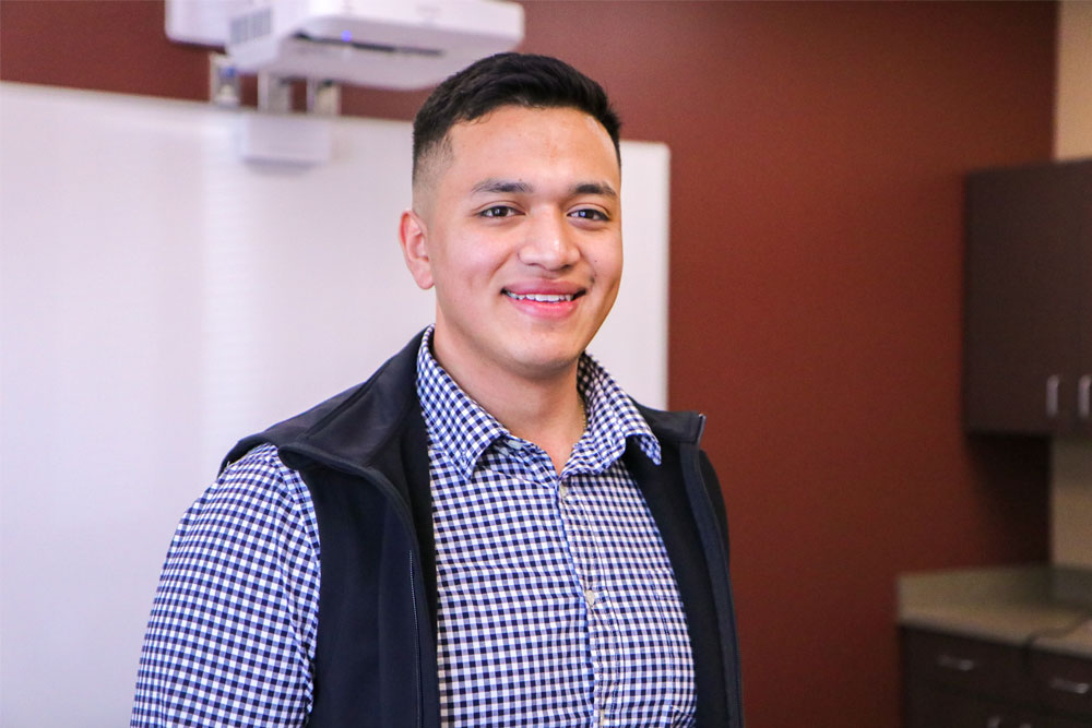 Carlos Trejo Perez poses for Student Story picture in a YVC classroom. 