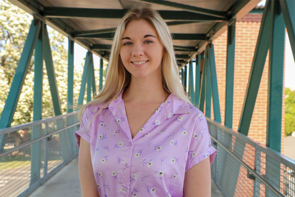 Kaidie Juarez poses for Student Story picture on the bridge at the Yakima Campus. 