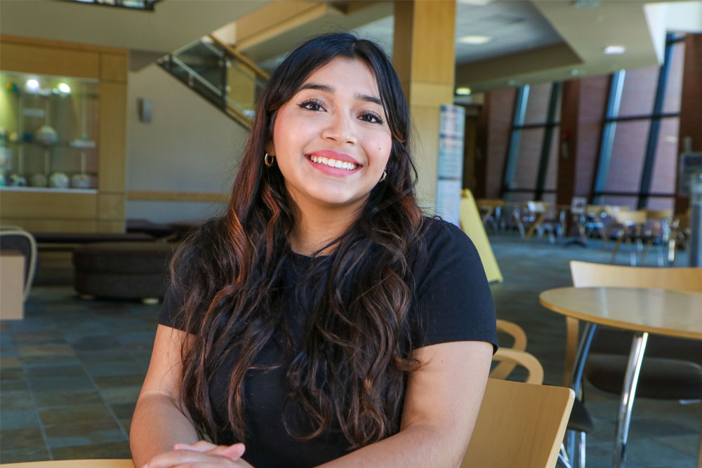 Mariah Cornejo poses for Student Story picture in a YVC common area. 