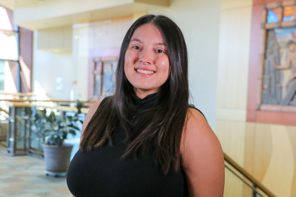 Ryn Gonzalez poses for Student Story picture at the top of the stairs in a YVC academic building. 