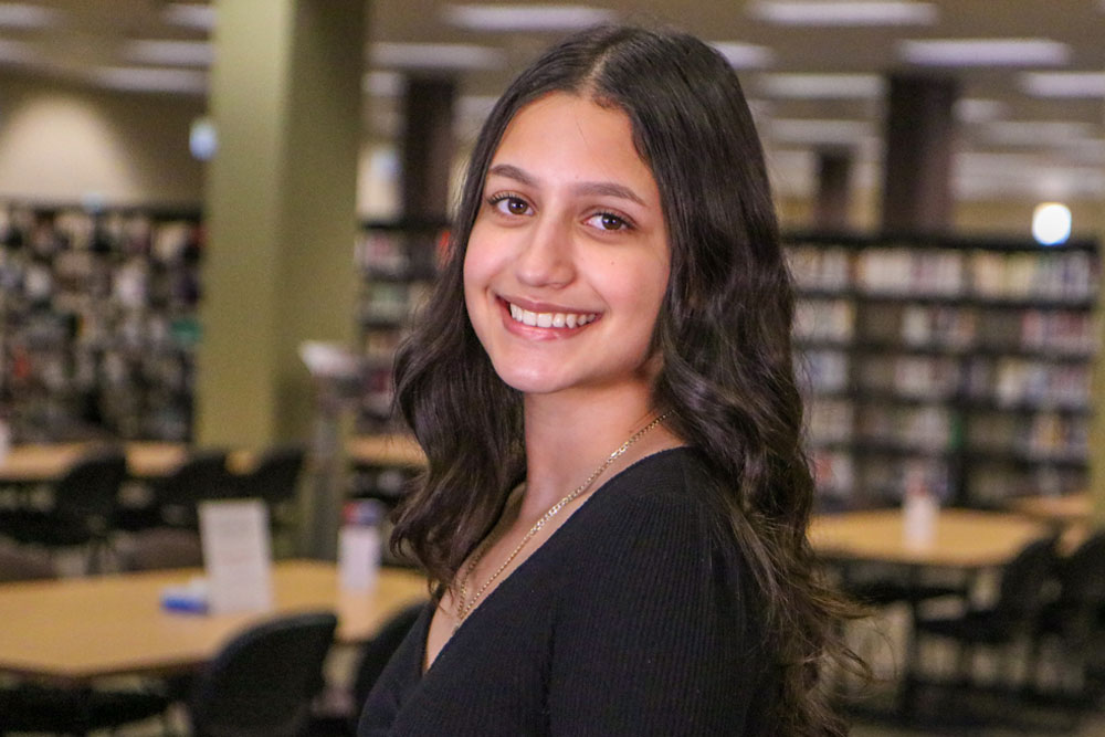 Valeria Vaca poses for picture with the YVC library in the background. 