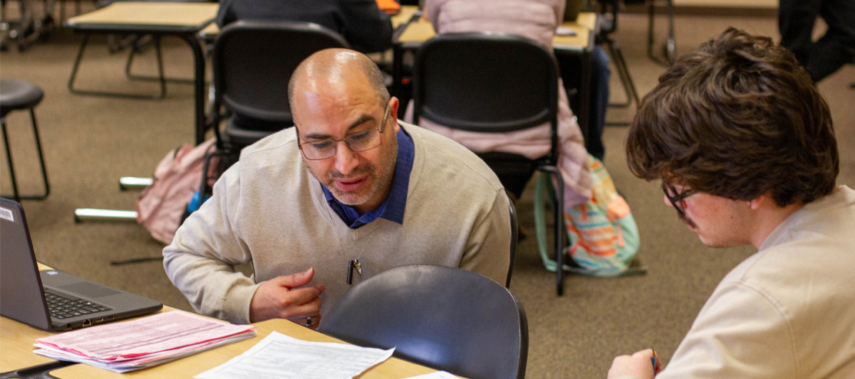 YVC Instructor assists a student at their computer. 