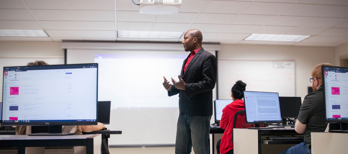 YVC teacher instructs his class in a computer lab. 