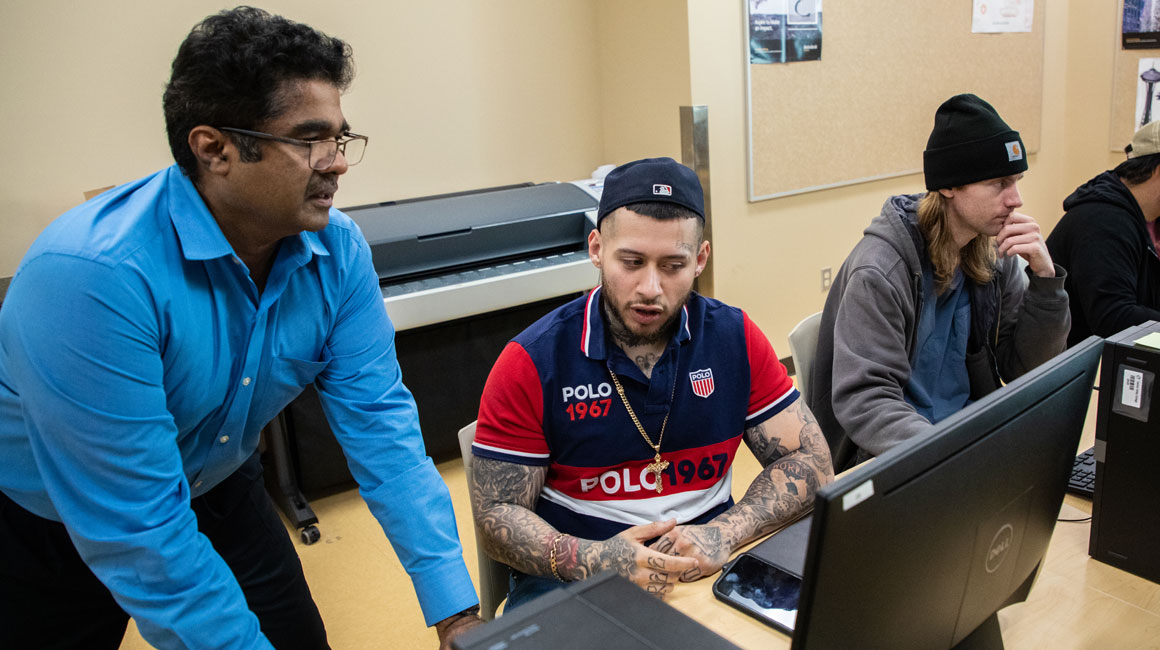 Instructor works with student in the computer lab. 