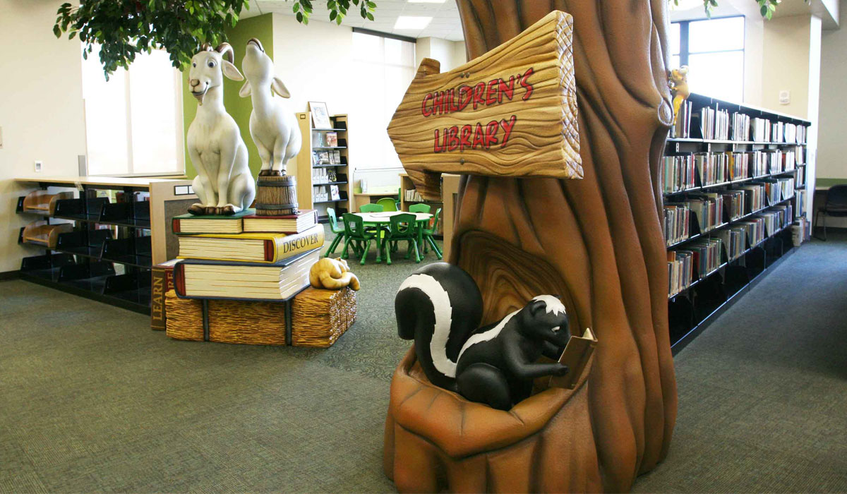 A skunk reading a book on a tree figurine displayed at the Grandivew Library. 