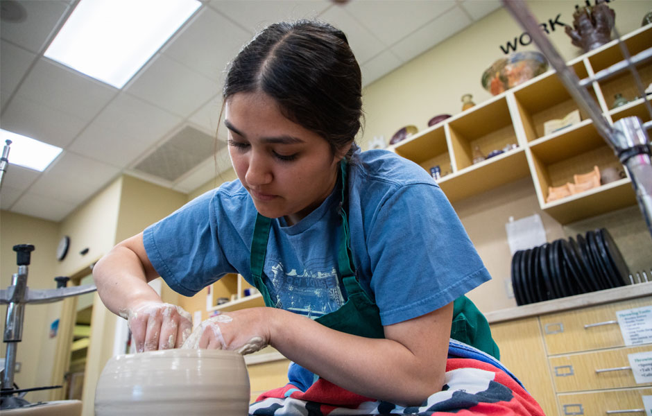 Student works with pottery wheel during art class. 