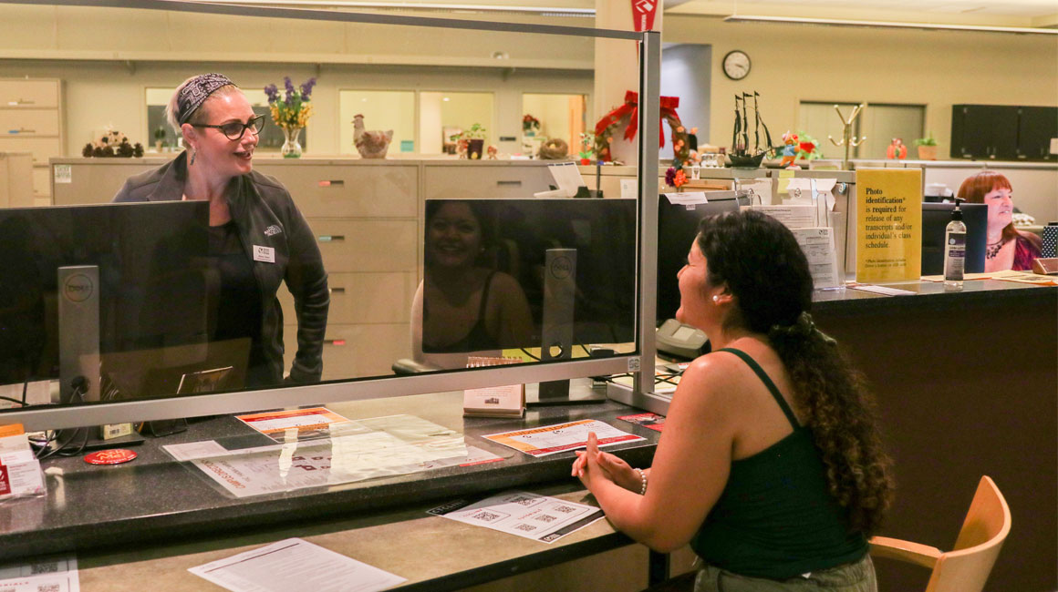 Student speaks to YVC employee at an admin building