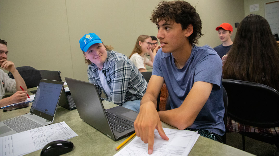 Student points to paper while asking a question during a YVC class. 